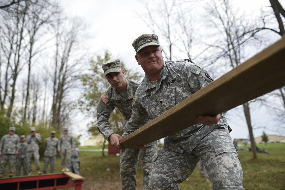 Spc. Brandon Coover, of Davenport, Iowa, and Spc. Jeffrey Hilderman, of Mexico, Mo., U.S. Army Reserve military police Soldiers with the 339th Military Police Company, lift a wooden board to navigate through a Leadership Reaction Course as part of a team-building exercise at Camp Atterbury, Ind., Nov. 5, during a three-day range training event hosted and organized by the 384th Military Police Battalion, headquartered at Fort Wayne, Ind. The field training involving more than 550 U.S. Army Reserve Soldiers and included ranges using eight different weapons systems, plus combat patrolling and a rifle marskmanship competition. (U.S. Army photo by Master Sgt. Michel Sauret)