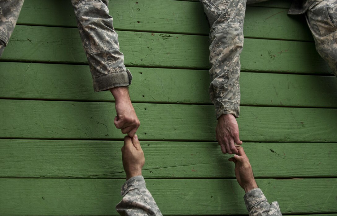 A Soldier's fingers slip throug his teammates' grasp as they try to navigate through a Leadership Reaction Course as part of a team-building exercise at Camp Atterbury, Ind., Nov. 5, during a three-day range training event hosted and organized by the 384th Military Police Battalion, headquartered at Fort Wayne, Ind. The field training involving more than 550 U.S. Army Reserve Soldiers and included ranges using eight different weapons systems, plus combat patrolling and a rifle marskmanship competition. (U.S. Army photo by Master Sgt. Michel Sauret)