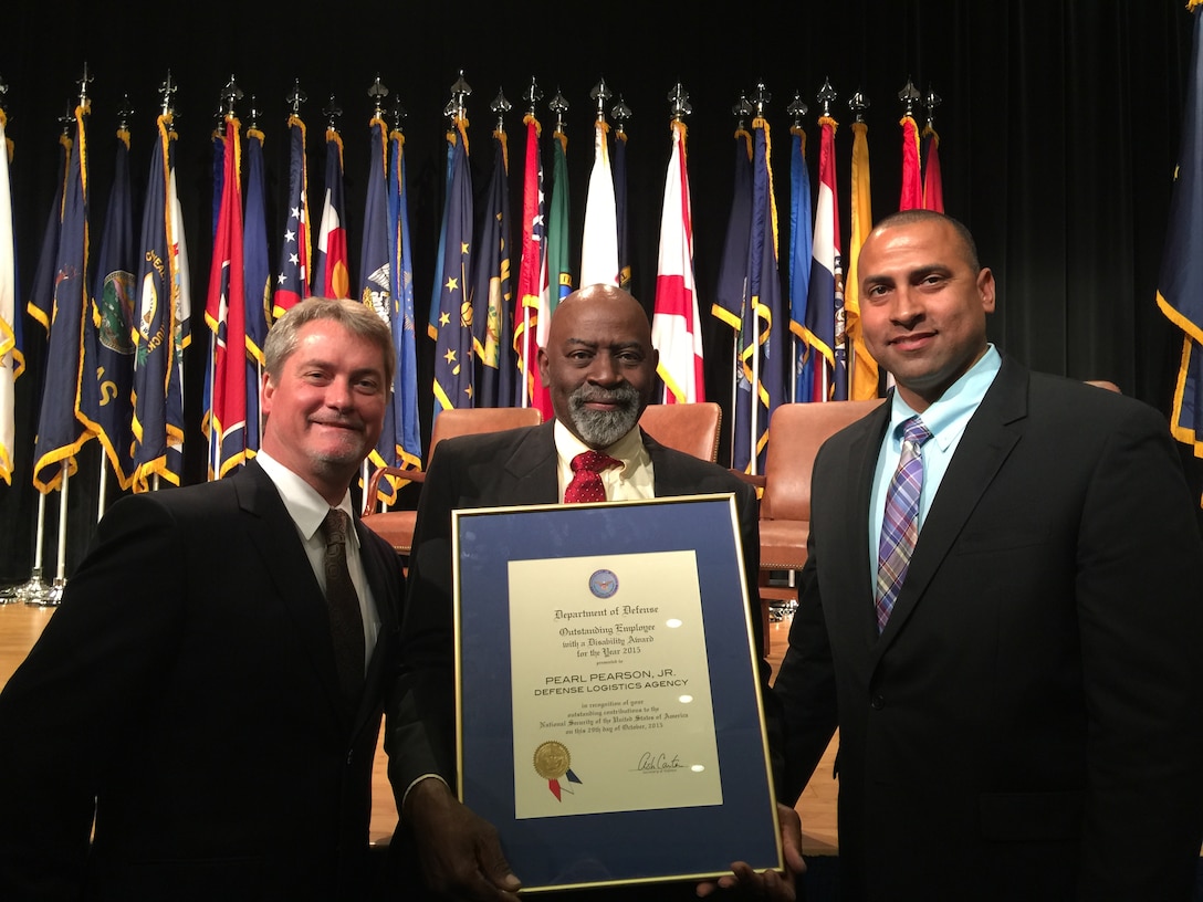 Terry Phillips and Dack Pearson, Pearl Pearson’s son, pose with Pearson at the 35th annual Department of Defense Disability Awards ceremony held in the Pentagon Auditorium on Oct. 29.