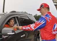 Chief Master Sgt. Brian Bischoff, 919th Special Operations Wing command chief, dresses as “Cal Naughton Jr.” from “Talladega Nights” to greet wing members at the gate at the beginning of the unit training assembly Nov. 6 at Duke Field.  The wing’s vice commander joined the chief dressed as “Ricky Bobby.”  (U.S. Air Force photo/Dan Neely)