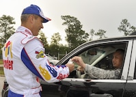 Col.  Robert Bruckner, 919th Special Operations Wing vice commander, dresses as “Ricky Bobby” from “Talladega Nights” to greet wing members at the gate at the beginning of the unit training assembly Nov. 6 at Duke Field.  The wing’s command chief joined the vice dressed as “Cal Naughton Jr.”  (U.S. Air Force photo/Dan Neely)