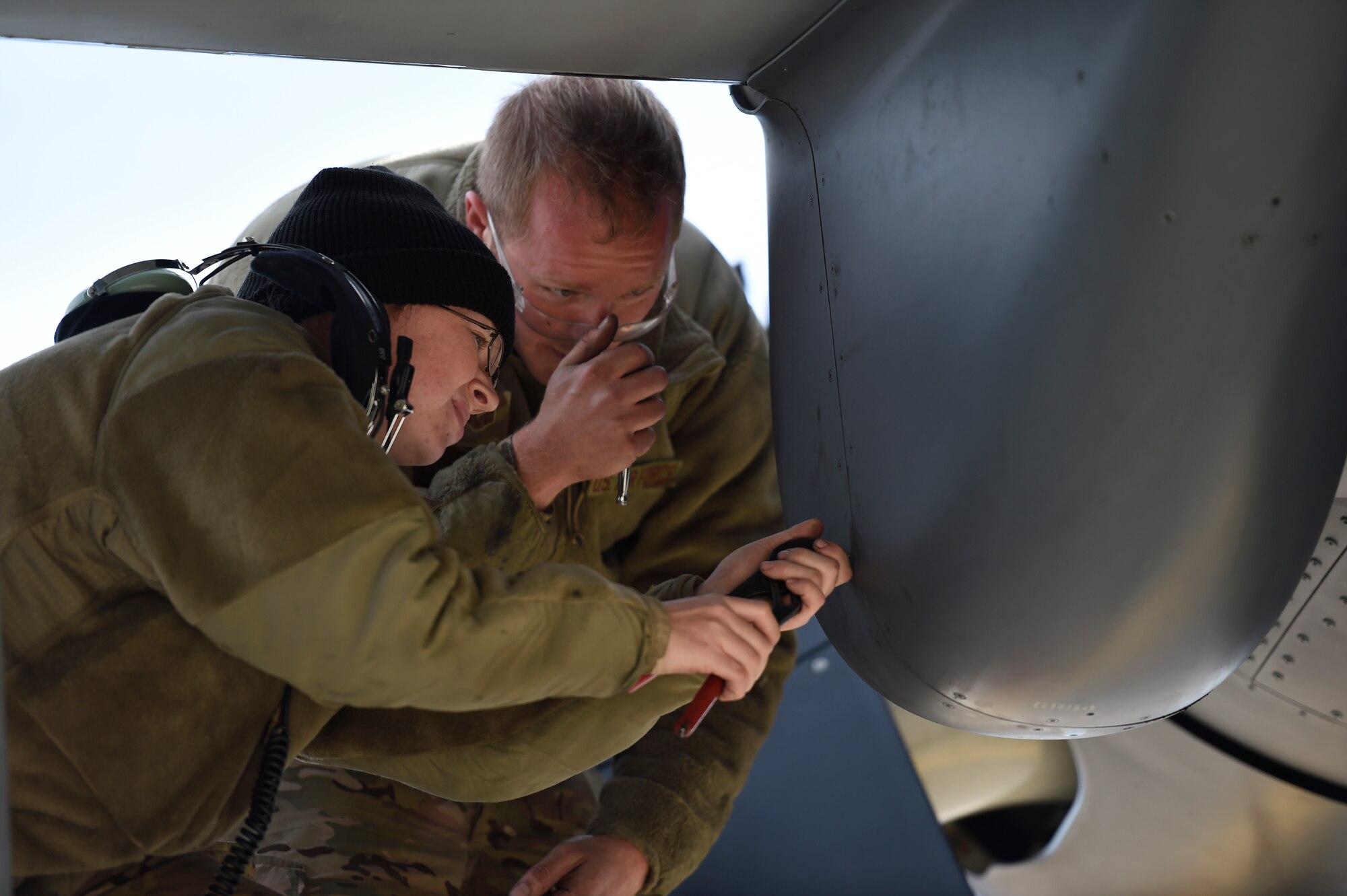 Staff Sgt. Melissa Moss and Senior Airman Daniel Gurka, crew chiefs with the 901st Aircraft Maintenance Squadron, reattach an engine cover after performing maintenance on a CV-22B Osprey at Hill Air Force Base, Utah, Nov. 2, 2015. The exercise allowed Airmen to perform their duties in a simulated expeditionary environment outside of their home stations. (U.S. Air Force by Airman Kai White)