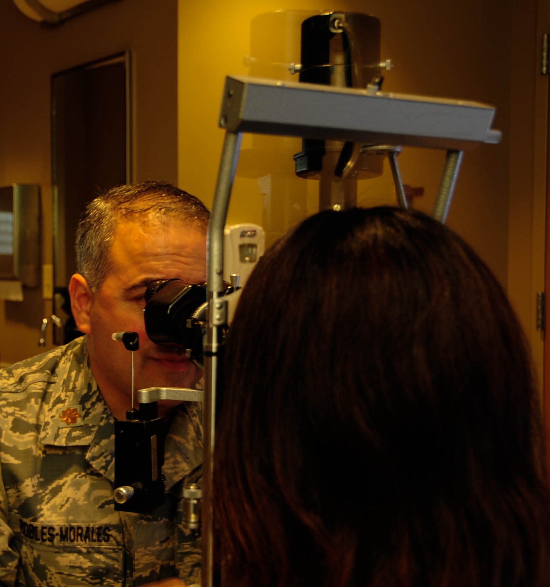 Maj. Gerardo I. Robles-Morales, 2nd Aerospace Medical Squadron Optometrist, looks at Chizu McCasland’s eye with a slit lamp at Barksdale Air Force Base, La., Oct. 22, 2015. The slit lamp provides a close look at the anterior area of the eye. This procedure ensures the patient's eyes are healthy and free of disease. (U.S. Air Force photo/Staff Sergeant Jason McCasland)
