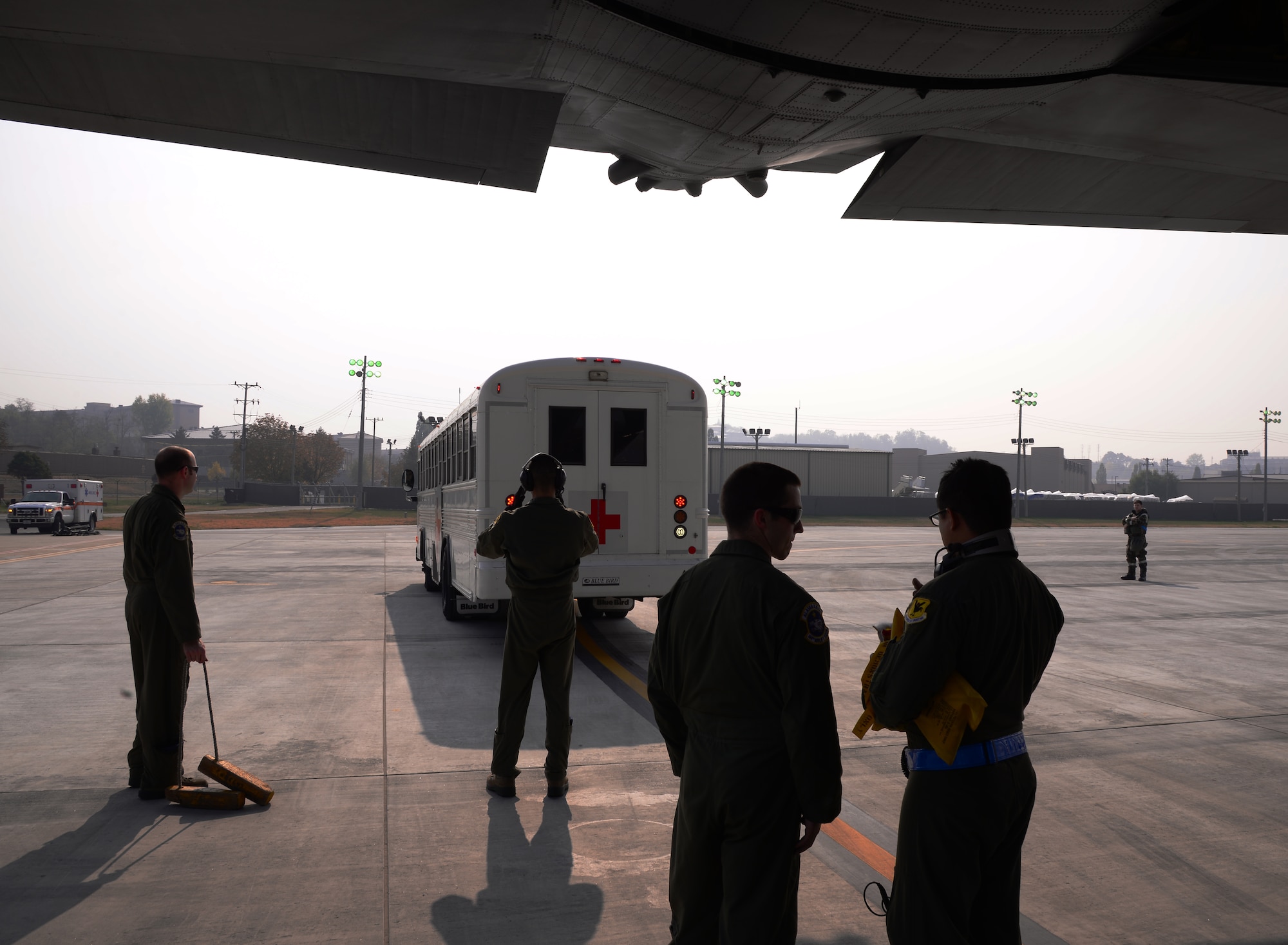 Members from the 144th Airlift Squadron Air National Guard, Joint Base Elmendorf-Richardson, Alaska, and 18th Aeromedical Evacuation Squadron, Kadena Air Base, Japan, await a bus containing simulated evacuation victims for transport on an HC-130 Combat King II cargo aircraft Nov. 5, 2015, at Osan Air Base, Republic of Korea. The squadrons are participating in Vigilant Ace 16, a large-scale exercise designed to enhance combat capabilities and interoperability of the U.S. and Republic of Korea Air Forces. (U.S. Air Force photo/Staff Sgt. Benjamin Sutton)
