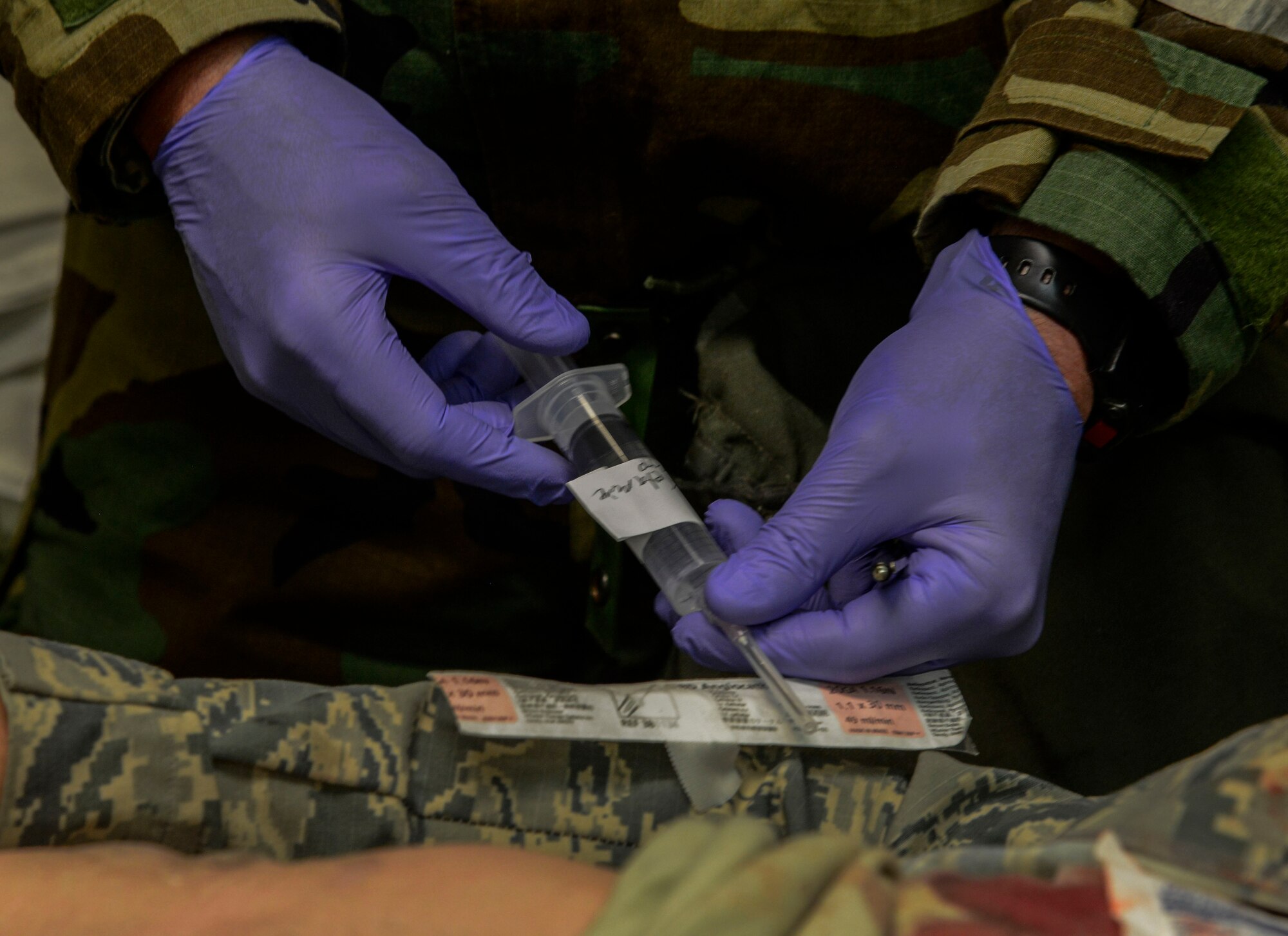 Maj. T.J. Szerszenski, 51st Medical Operations Squadron emergency services element chief, simulates giving a patient pain medication during the Vigilant Ace 16 exercise on Osan Air Base, Republic of Korea, Nov. 3, 2015. The MDOS Airmen act out each scenerio with role-playing patients to ensure every step is correctly taken as they would in real life, in an effort to save the exercise player. (U.S. Air Force photo/Senior Airman Kristin High)