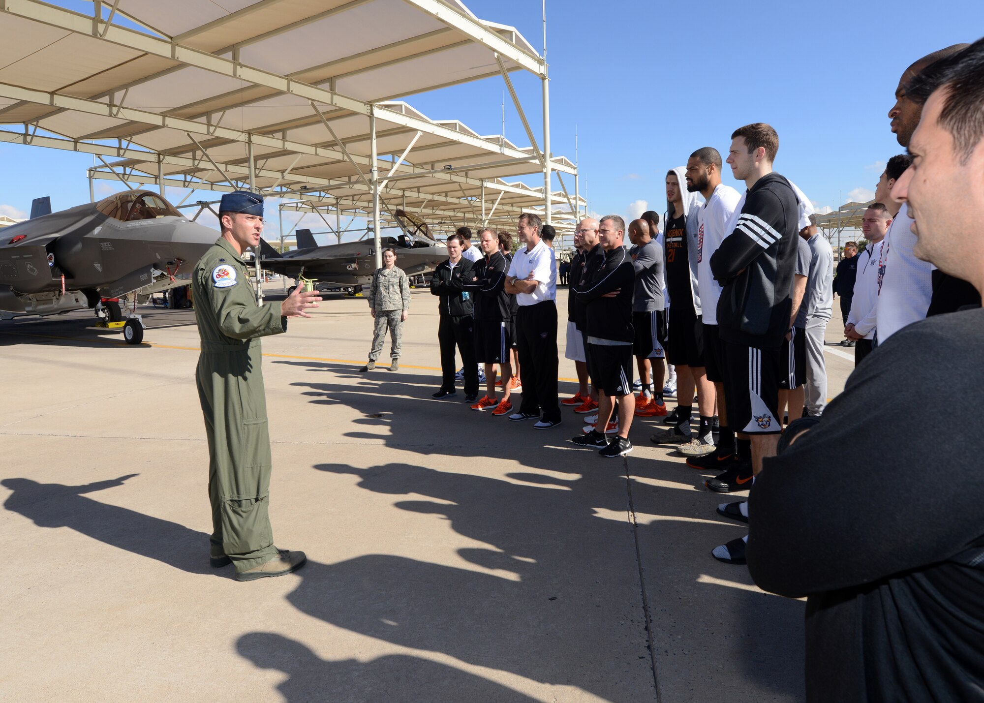 Lt. Col Matthew Vedder, 62nd Fighter Squadron director of operations, gives the Phoenix Suns basketball team a briefing on the F-35A Lightning II November 5, 2015, on Luke Air Force Base, Arizona. The Phoenix Suns visited Luke to meet Airmen and perform a practice demonstration at the Bryant Fitness Center. (U.S. Air Force photo by Staff Sgt. Marcy Copeland)