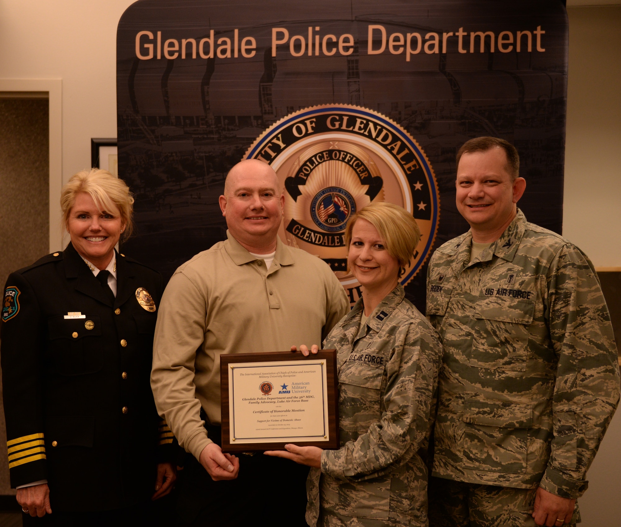 Debora Black, Glendale Chief of Police, Sgt. Patrick Beumler, Glendale Criminal Investigations Officer, Capt. Sonja Raciti, Luke Family Advocacy Officer, and Col. Stephen Boden, commander of the 56th Medical Operations Squadron, pose with an International Association of Chiefs of Police award Nov. 5, at the Glendale Family Advocacy Center. The award was presented to both the Glendale Police Department and the Luke FAC in honor of their joint efforts to support and protect victims of domestic violence and abuse. (U.S. Air Force photo by Airman 1st Class Ridge Shan)