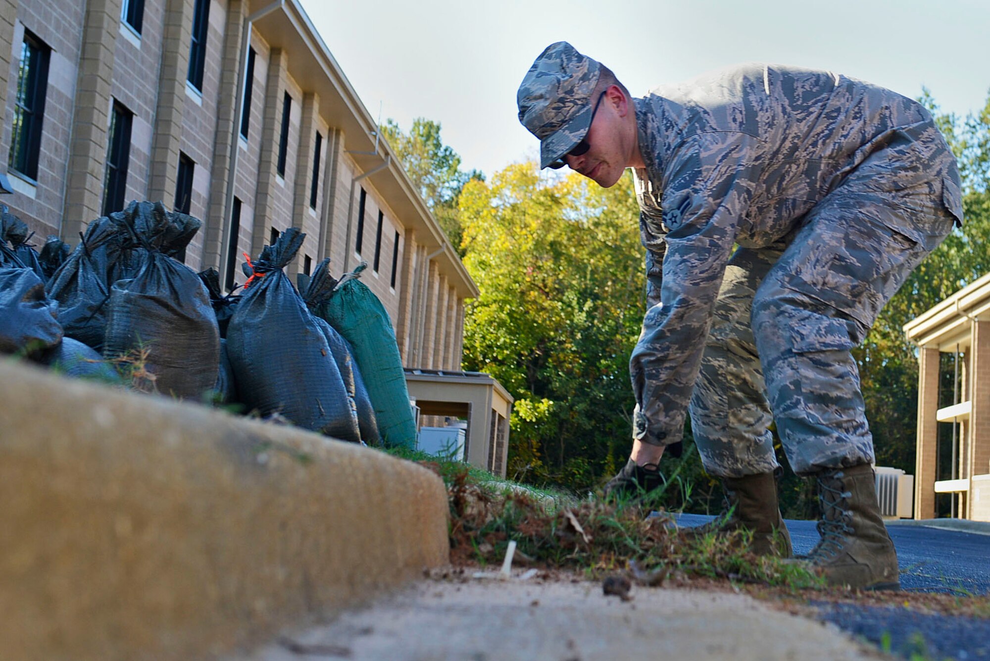 A U.S. Airman clears excess dirt during a dorm cleanup event at Shaw Air Force Base, S.C., Oct. 30, 2015.  After receiving dorm inspections from their supervisors, Airmen cleaned around the nine dorm buildings. (U.S Air Force photo by Airman 1st Class Christopher Maldonado)