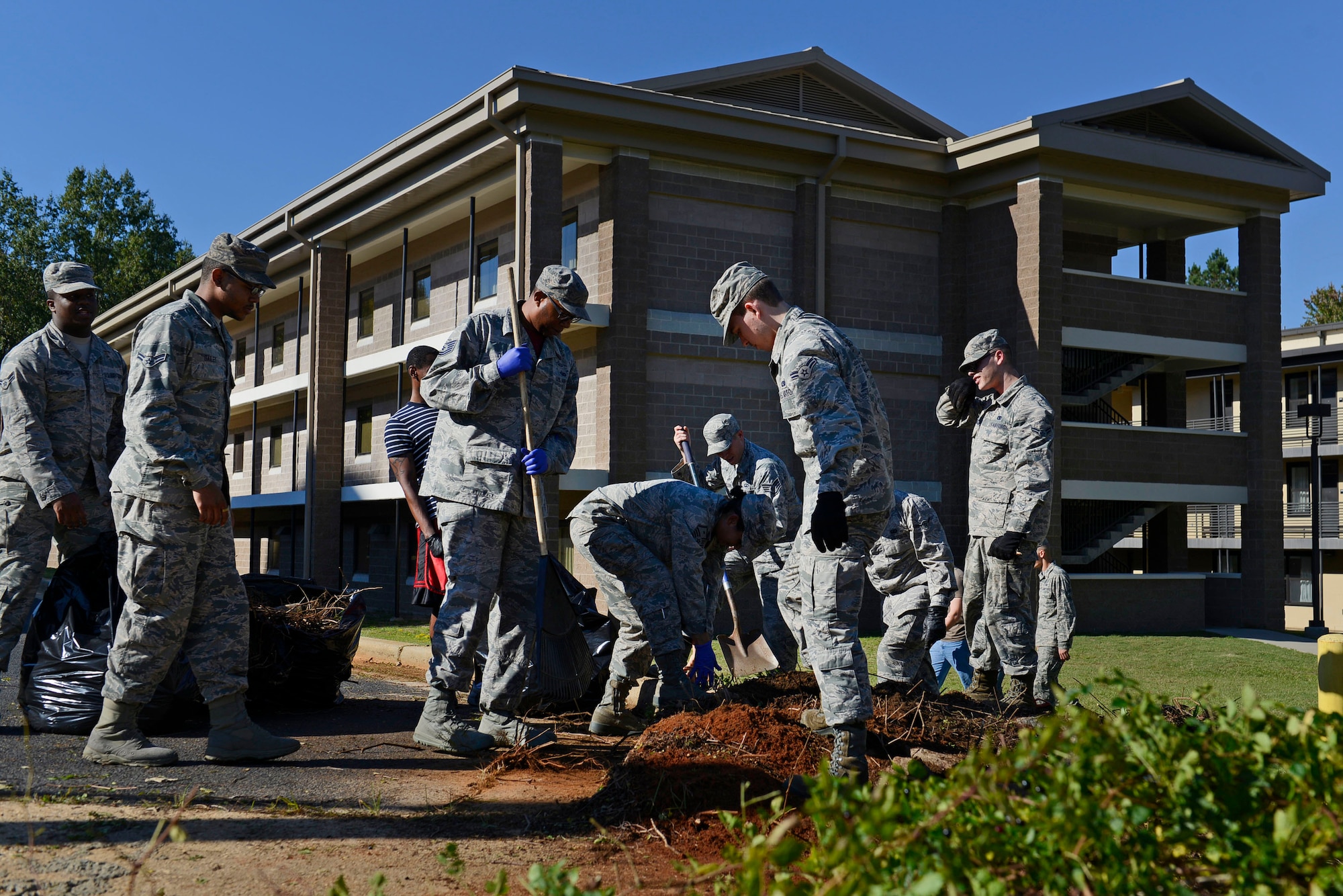 U.S. Air Force Airmen work together to clear debris around the nine dorms during a dorm cleanup event at Shaw Air Force Base, S.C., Oct. 30, 2015. The event gave supervisors the opportunity to engage with their Airmen, and make sure that their dorm needs are being met. (U.S Air Force photo by Airman 1st Class Christopher Maldonado)