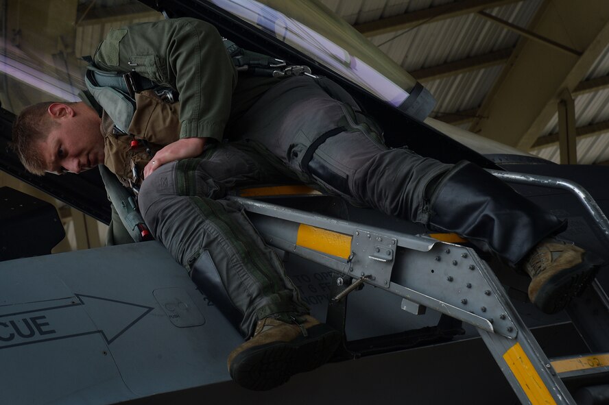 A U.S. Air Force F-16CM Fighting Falcon pilot inspects the inside of a cockpit, during operational readiness exercise Weasel Victory 16-02 at Shaw Air Force Base, S.C., Nov. 5, 2015. The ORE tested the combat readiness and capabilities of the wing through a variety of simulated events. (U.S. Air Force photo by Senior Airman Michael Cossaboom)