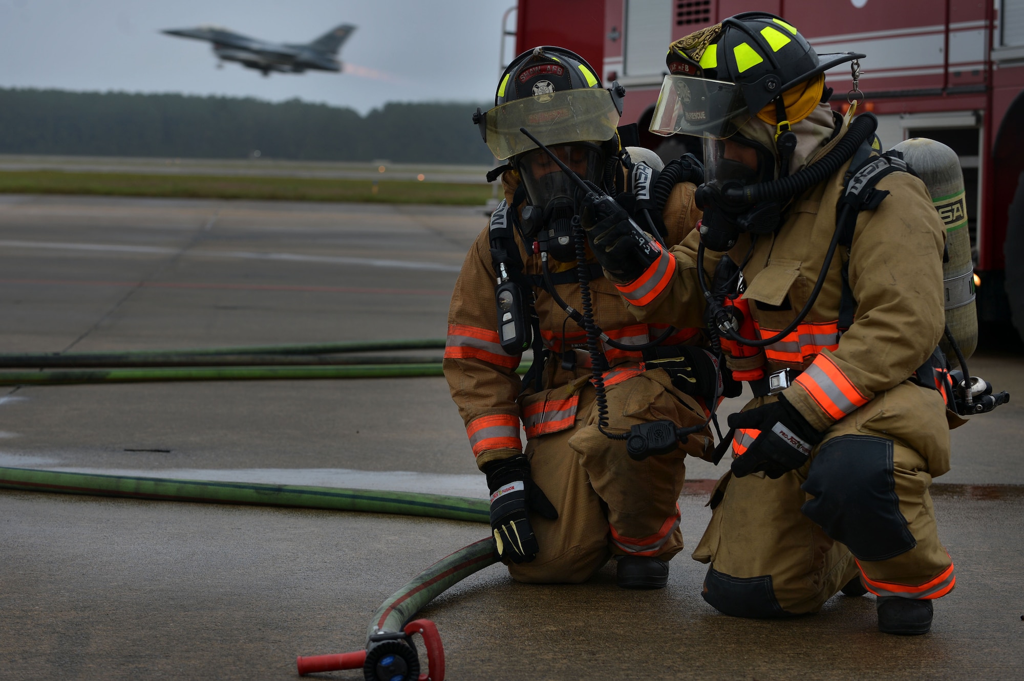 An F-16CM Fighting Falcon takes-off as Airmen with the 20th Civil Engineer Squadron respond to a simulated aircraft incident during operational readiness exercise Weasel Victory 16-02, at Shaw Air Force Base, S.C., Nov. 3, 2015. The ORE tested the combat capabilities of the 20th Fighter Wing through a variety of simulated scenarios and events. (U.S. Air Force photo by Senior Airman Michael Cossaboom)