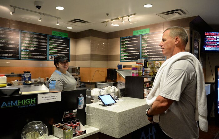 Laura Martens, Aim High Café shift lead, takes an order from Col. Bo Marzolf, 414th Combat Training Squadron commander, at the Warrior Fitness Center on Nellis Air Force Base, Nev., Nov. 3, 2015. The café offers a variety of healthy foods and drinks for fitness center patrons. (U.S. Air Force photo by Airman 1st Class Rachel Loftis)