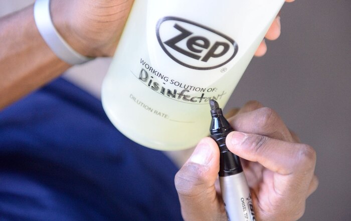 Brian Freeman, 99th Force Support Squadron fitness specialist, writes on a bottle of disinfectant at the WFC on Nellis Air Force Base Nev., Nov.3, 2015. Airmen of the fitness center refill and maintain disinfectant spray for gym members to wipe down equipment with. (U.S. Air Force photo by Airman 1st Class Rachel Loftis)