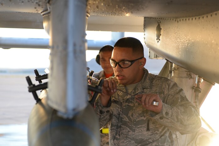 Airman 1st Class Jordan Palomo, Thunder Aircraft Maintanence Unit weapons load crew member, prepares to load a munition during a quarterly weapons load crew competition on Nellis Air Force Base, Nev., Oct. 23, 2015. Weapons loaders are responsible for inspections, repairs and maintenance on aircraft release, launch, suspension and monitor systems of munitions. (U.S. Air Force photo by Senior Airman Mikaley Kline)