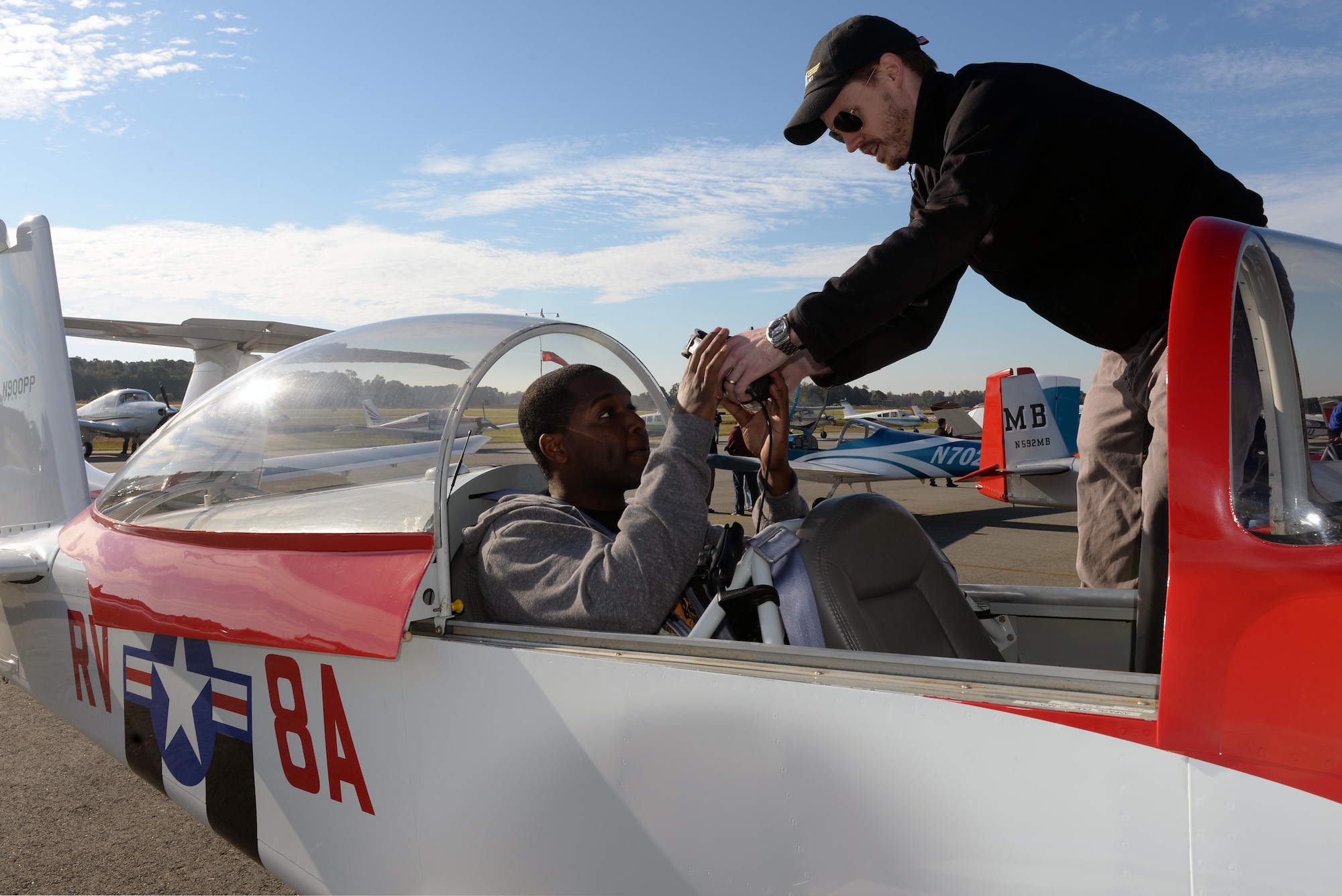 Everett Hite (right) prepares Senior Airman Robert Shobe, 4th Operations Support Squadron air traffic controller, for flight during the Scare-A-Controller event, Oct. 31, 2015, at Wayne Executive Jetport in Goldsboro, North Carolina. The inaugural event was held to thank air traffic controllers for their role in protecting assets in the skies. (U.S. Air Force photo/Senior Airman John Nieves Camacho)