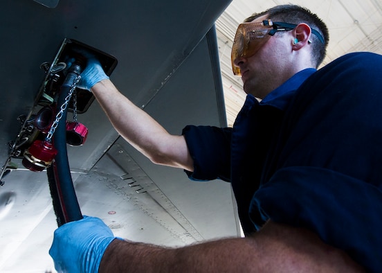 Staff Sgt. Nathaniel Gladney, a dedicated crew chief with the 54th Aircraft Maintenance Squadron at Holloman, attaches drain hoses to an F-16 Fighting Falcon before performing aircraft purification Nov. 4. Aircraft purification is the process to remove water, air and contaminant particles from the hydraulic fluid of an aircraft. Holloman Airmen performed this process for the first time on an F-16 on Nov. 3.  (U.S. Air Force photo by Airman 1st Class Emily A. Kenney/Released)     