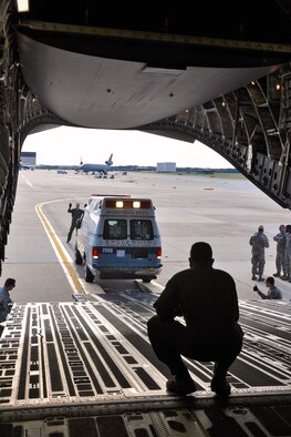 Aerial porters and loadmasters from the 514th Air Mobility Wing load an ambulance onto a C-17 Globemaster III cargo plane on the flightline at Joint Base McGuire-Dix-Lakehurst, N.J., Oct. 10. The ambulance will be delivered to a humanitarian organization in Haiti as part of a Denton cargo mission, which allows humanitarian cargo to fly on U.S. military aircraft on a space-available basis. (U.S. Air Force photo by Tech. Sgt. Jonathan E. White) 