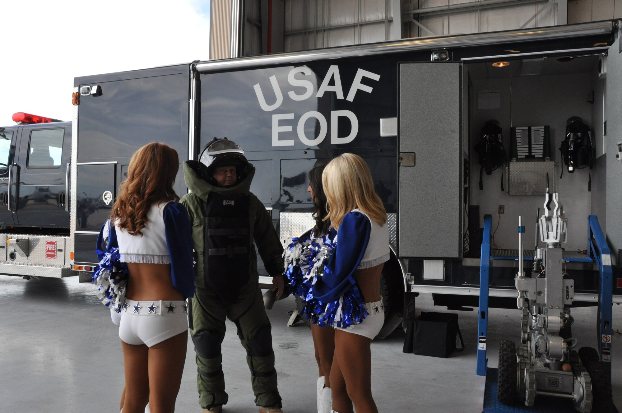 Tech. Sgt. Guy Smith, 301st Civil Engineer Squadron’s Explosive Ordnance Disposal team member, demonstrated the bomb suit and equipment to Dallas Cowboys Cheerleaders at Naval Air Station Fort Worth Joint Reserve Base today. Dallas Cowboys’ alumni, cheerleaders and mascot, Rowdy, visited the base to say thanks to active duty and Reserve Airmen, Soldiers, Sailors, and Marines. The Cowboys and National Football League's Sunday Night Football vans were on hand for everyone. (Air Force photo/Capt. Candice Allen)