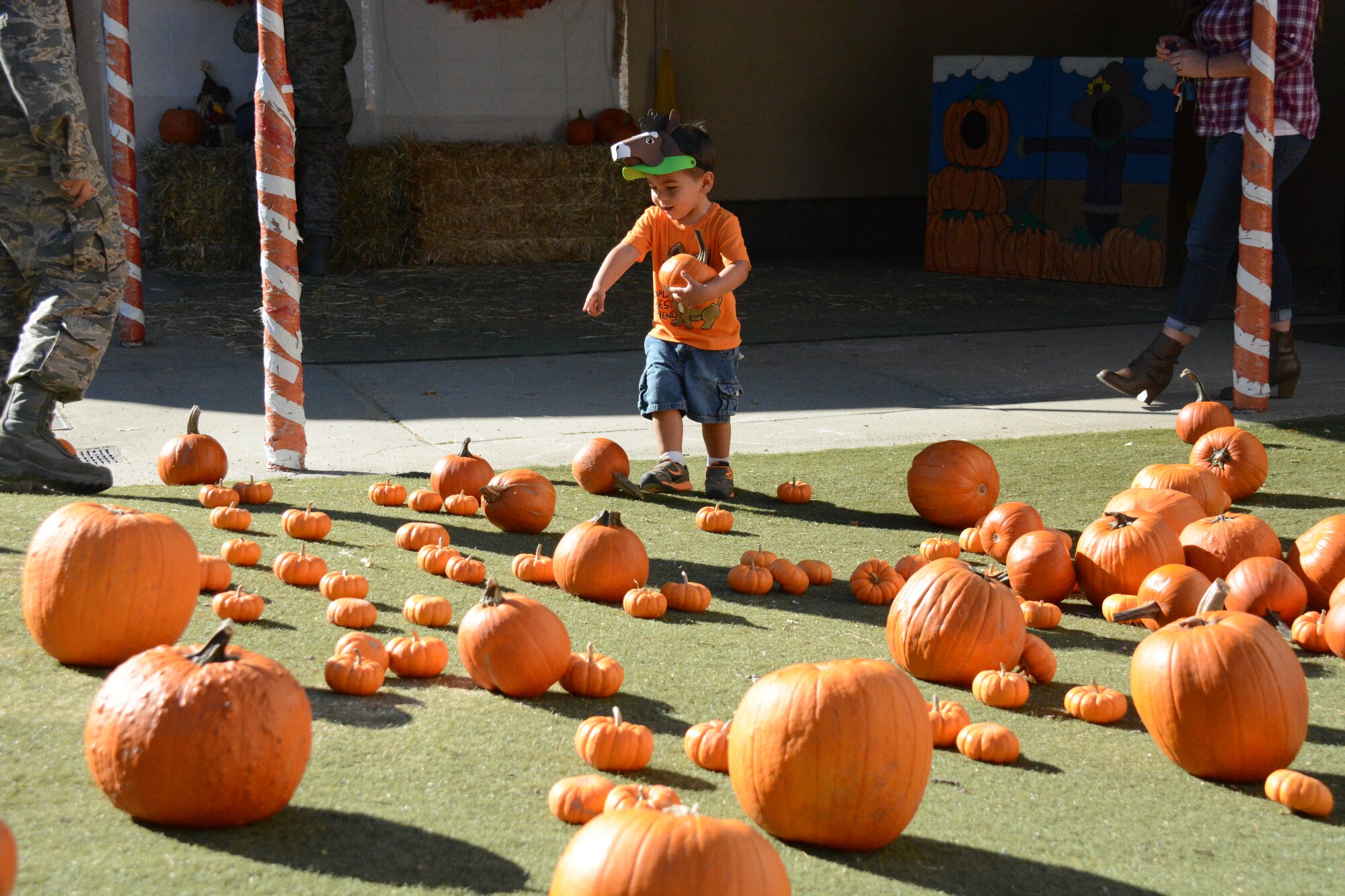 A child selects a pumpkin Oct. 30 at the CDC Harvest Festival at Travis Air Force Base, California. Children were able to pick a pumpkin and take it home. (U.S. Air Force photos by Airman 1st Class Amber Carter)