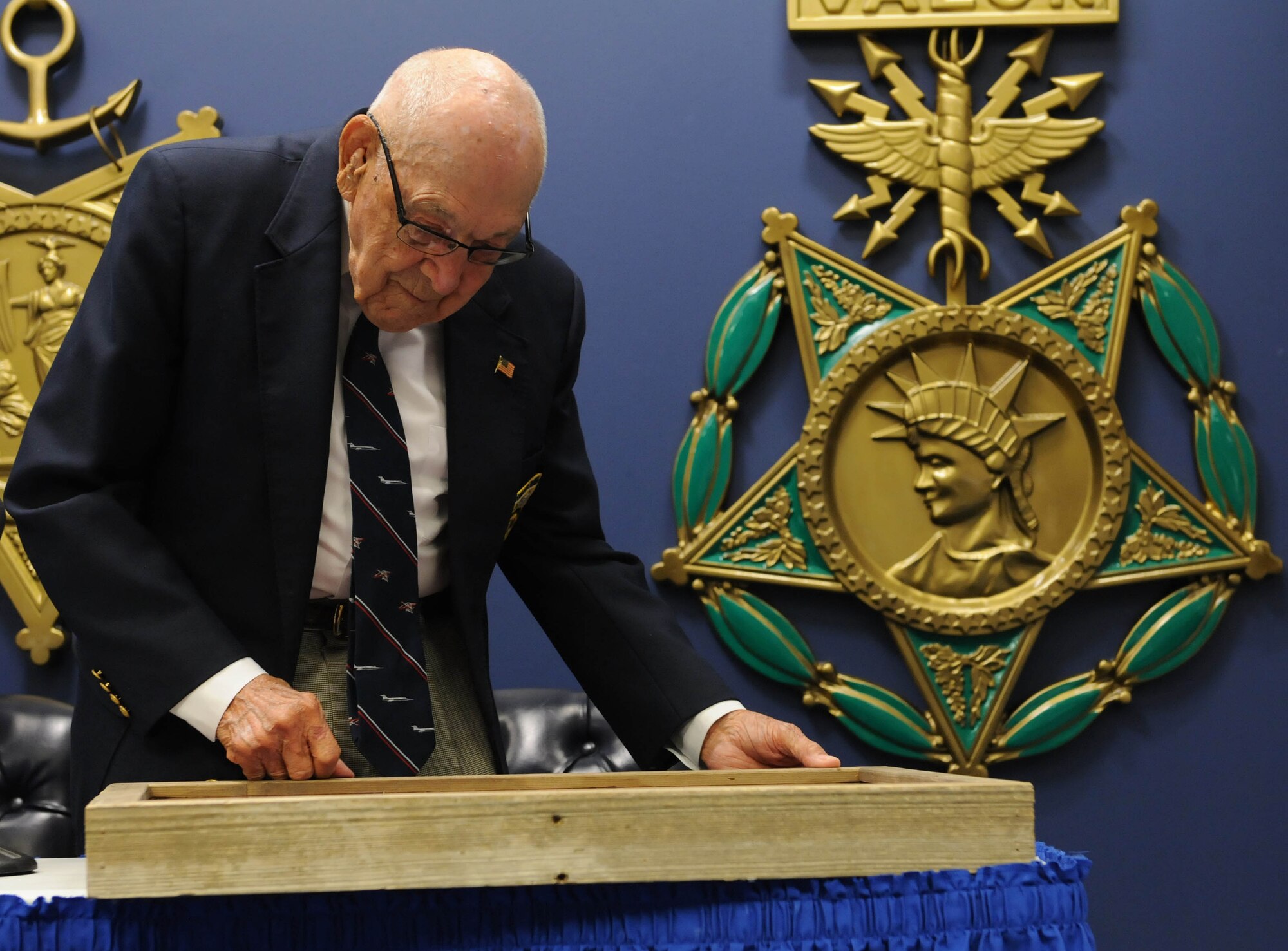 Retired Lt. Col. Dick Cole, one of two surviving Doolittle Raiders, admires a shadowbox presented to him at the Pentagon, Arlington, Va., Nov. 5, 2015. Cole was the co-pilot of the first B-25 to launch off the deck of the USS Hornet with Lt. Col. James Doolittle during the Doolittle Raid in 1942. (U.S. Air Force photo by Staff Sgt. Carlin Leslie/Released)