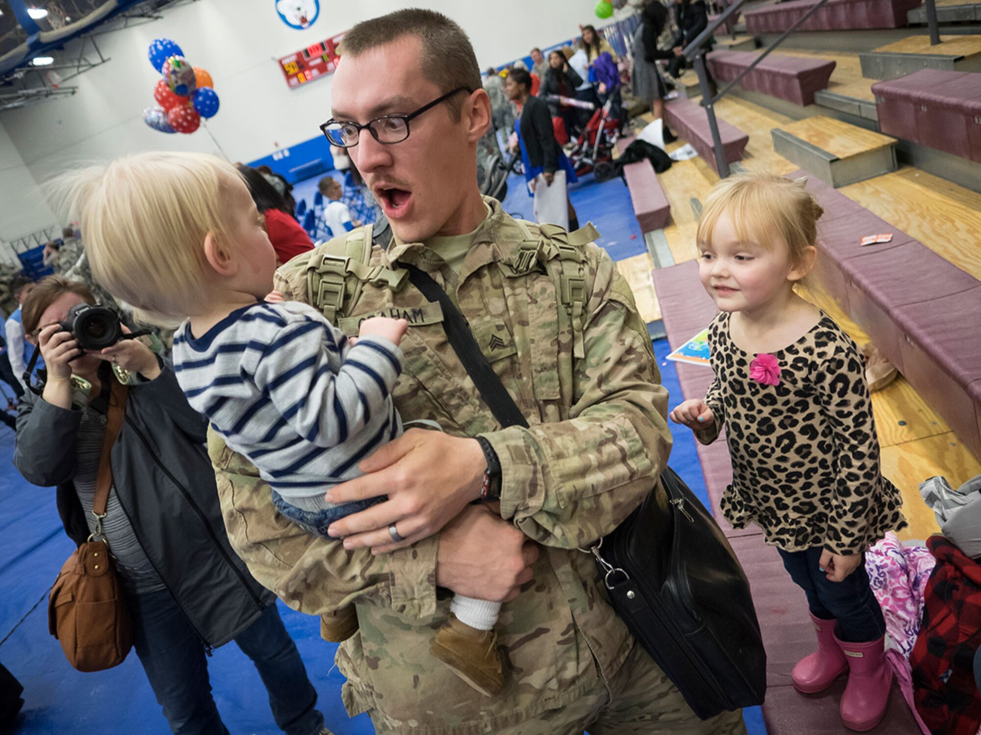 Spc. William Goodwin, assigned to the 98th Maintenance Company, 17th Combat Sustainment Support Battalion, U.S. Army Alaska, reunites with his wife Holly Goodwin, step-daughter Ashlynn Deer, 7, and daughter Maci Goodwin, 4, during a redeployment ceremony at the Buckner Physical Fitness Center Wednesday. (U.S. Air Force Photo/Airman Valerie Monroy)