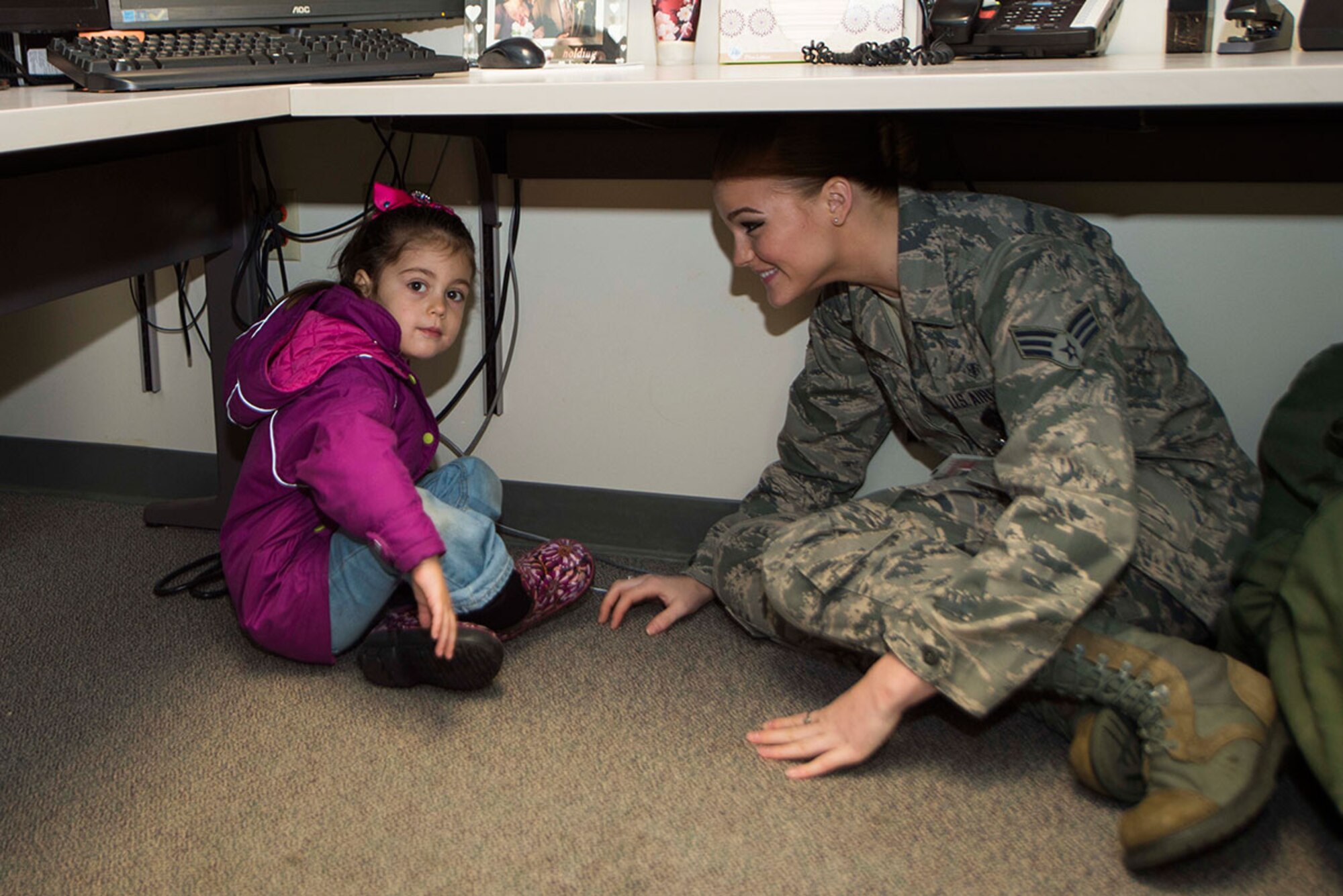 Senior Airman Nicole Hutton and Luciana Humprey, age 4, demonstrate how the 673d Medical Group staff responded to the Oct. 16 incident. The hospital was put on lockdown around 12:30 p.m. as security and emergency response personnel responded to a report of an agitated customer with a firearm. Hutton is assigned to 673d Medical Operations Squadron as a medical technician. (U.S. Air Force photo/Staff Sgt. Sheila deVera)