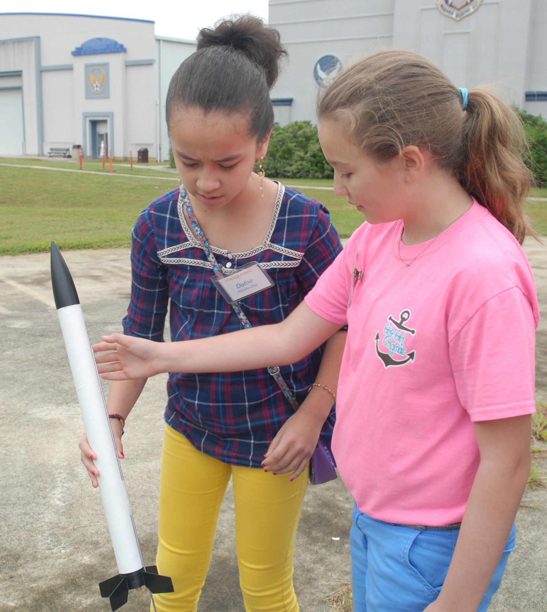 Dafne Moralos-Diaz (left) and Emily Hatfield, Porter Elementary 5th graders, attach the rocket to the launch pad before they launch it at the Museum of Aviation’s amphitheater.   (U.S. Air Force photo by Misuzu Allen)
