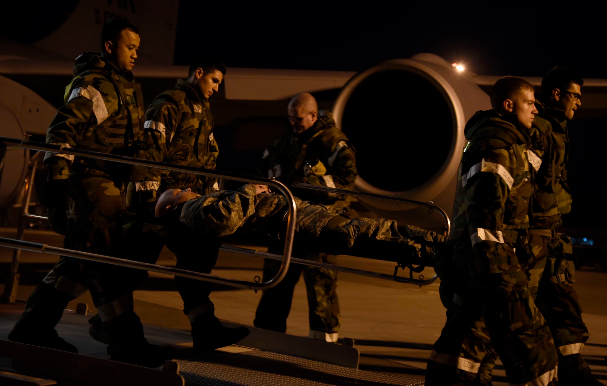 Members of the 35th Medical Group carry an Airman on a litter at Misawa Air Base, Japan, Nov. 4, 2015. As part of exercise Vigilant Ace 16, patients were carried from a KC-135 Stratotanker to hospital transport vehicles. The scenario allowed Airmen to respond to a variety of injures and scenarios. (U.S. Air Force photo by Airman 1st Class Jordyn Fetter/Released)