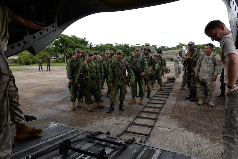 Belizean security forces are briefed on properladder climbing techniques by U.S. Army CH-47 Chinook helicopter flight engineers prior to a training mission held in Belize, Oct. 26, 2015. The Belizean security forces and the Army worked together to eradicate several marijuana fields identified throughout Belize during the four-day operation, with the CH-47s providing airlift support. (U.S. Air Force photo by Senior Airman Westin Warburton/Released)