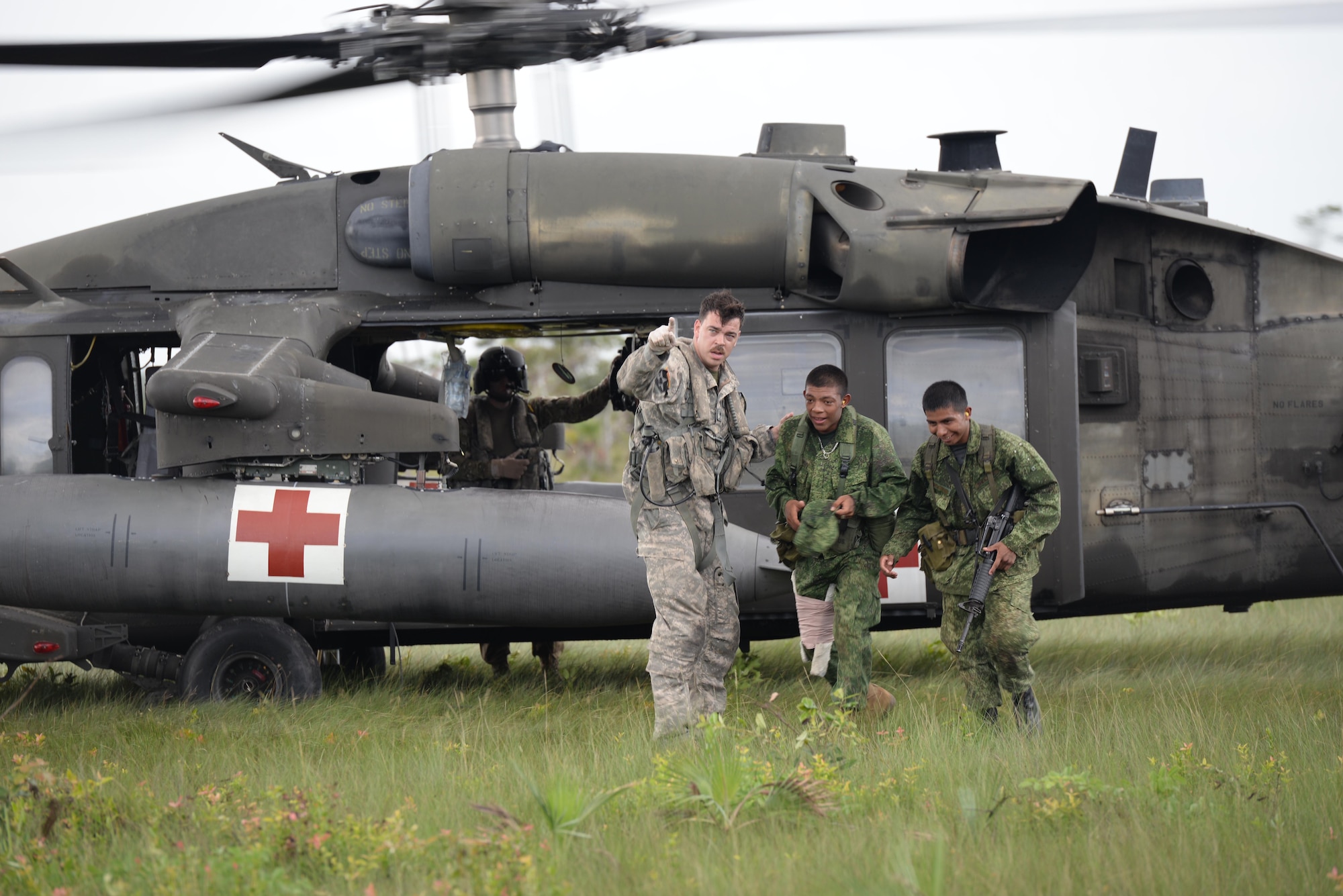 U.S. Army Staff Sgt. Zach Lattimore, 1-228 Aviation Regiment flight medic, gives directions to Belizean security forces during a mock medical evacuation mission, Oct. 26, 2015, in Belize. The mock mission was part of the training the Belizean security forces and U.S. Army conducted prior to a four-day long drug eradication mission. (U.S. Air Force photo by Senior Airman Westin Warburton/Released)