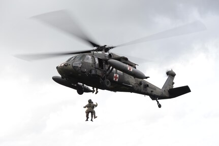 U.S. Army Staff Sgt. Zach Lattimore, 1-228 Aviation Regiment flight medic, and a Belize Defense Force member are hoisted into a UH-60 Blackhawk helicopter during a mock medical evacuation mission, Oct. 26, 2015, in Belize. The U.S. Army provided airlift capabilities to the Belizean forces during an operation to eradicate marijuana fields throughout Belize, which was proceeded by training missions to familiarize the Belizeans with the U.S. aircraft and techniques. (U.S. Air Force photo by Senior Airman Westin Warburton/Released)