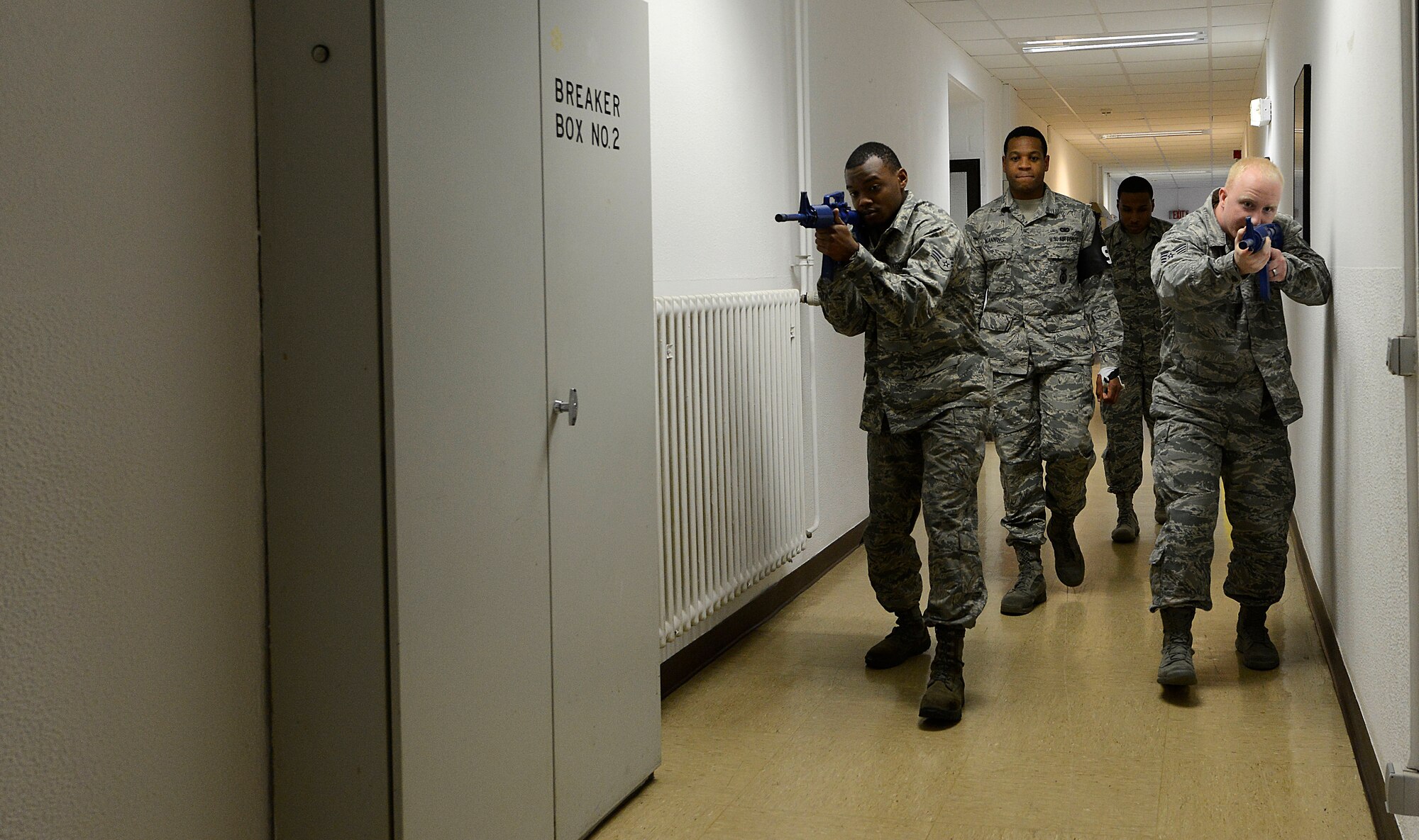 Two students from the Expeditionary Active Shooter Training class, followed by their instructors, search a hallway as they make their way to an exit during an active shooter scenario Nov. 5, 2015, at Ramstein Air Base, Germany. The E.A.S.T. class is a requirement for deploying Airmen and includes hands-on practical training to further prepare the student for a real active shooter situation. (U.S. Air Force photo/Airman 1st Class Tryphena Mayhugh)