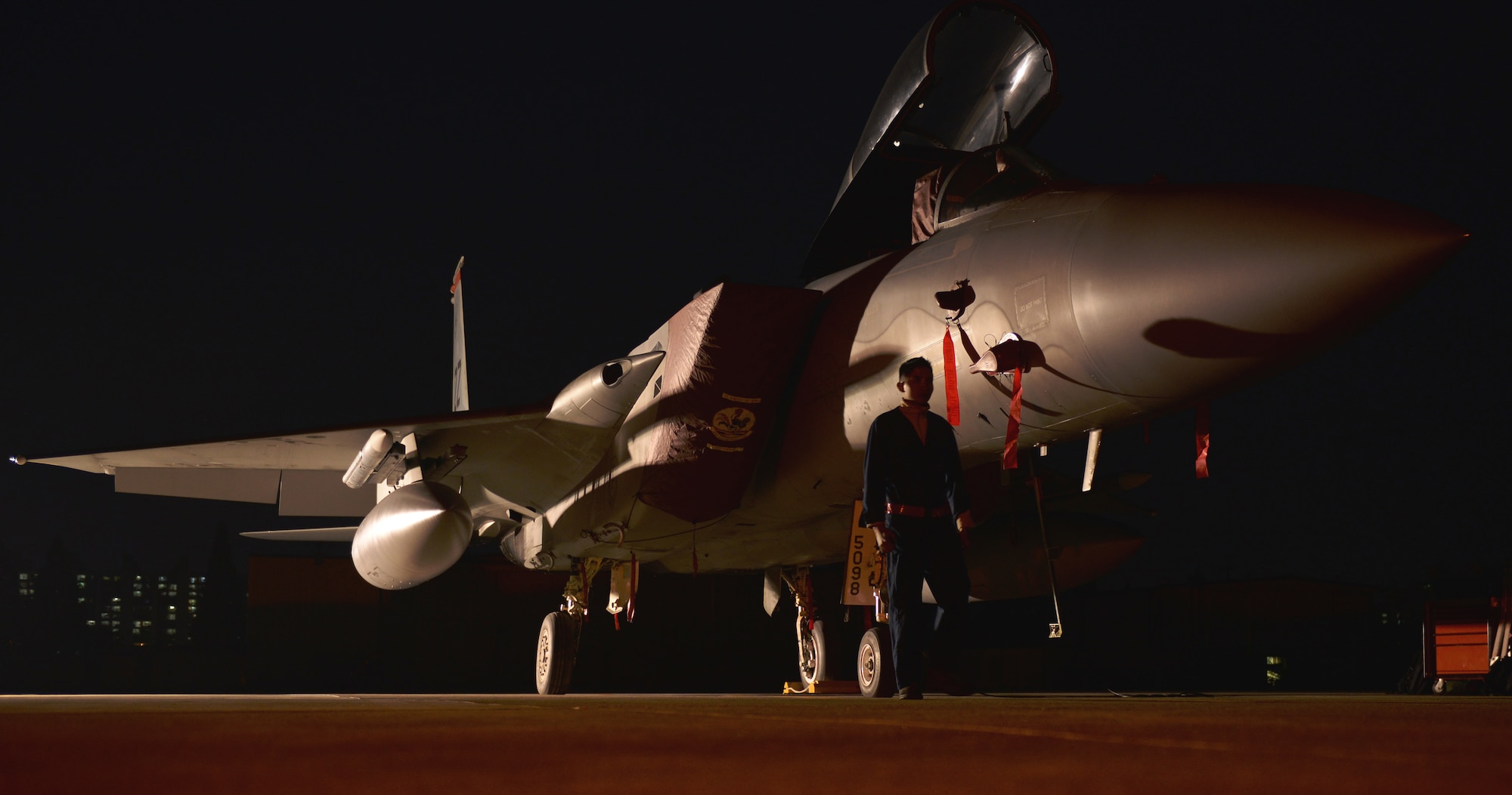 Senior Airman Dennis Franco, 67th Fighter Squadron Aircraft Maintenance Unit crew chief, performs a final check on an F-15 Eagle before turning it over to the next shift Nov. 2, 2015, at Gwangju Air Base, Republic of Korea. Airmen work around the clock to ensure the jets are ready to deploy at a moment's notice to maintain combat readiness. (U.S. Air Force photo/Senior Airman Omari Bernard)