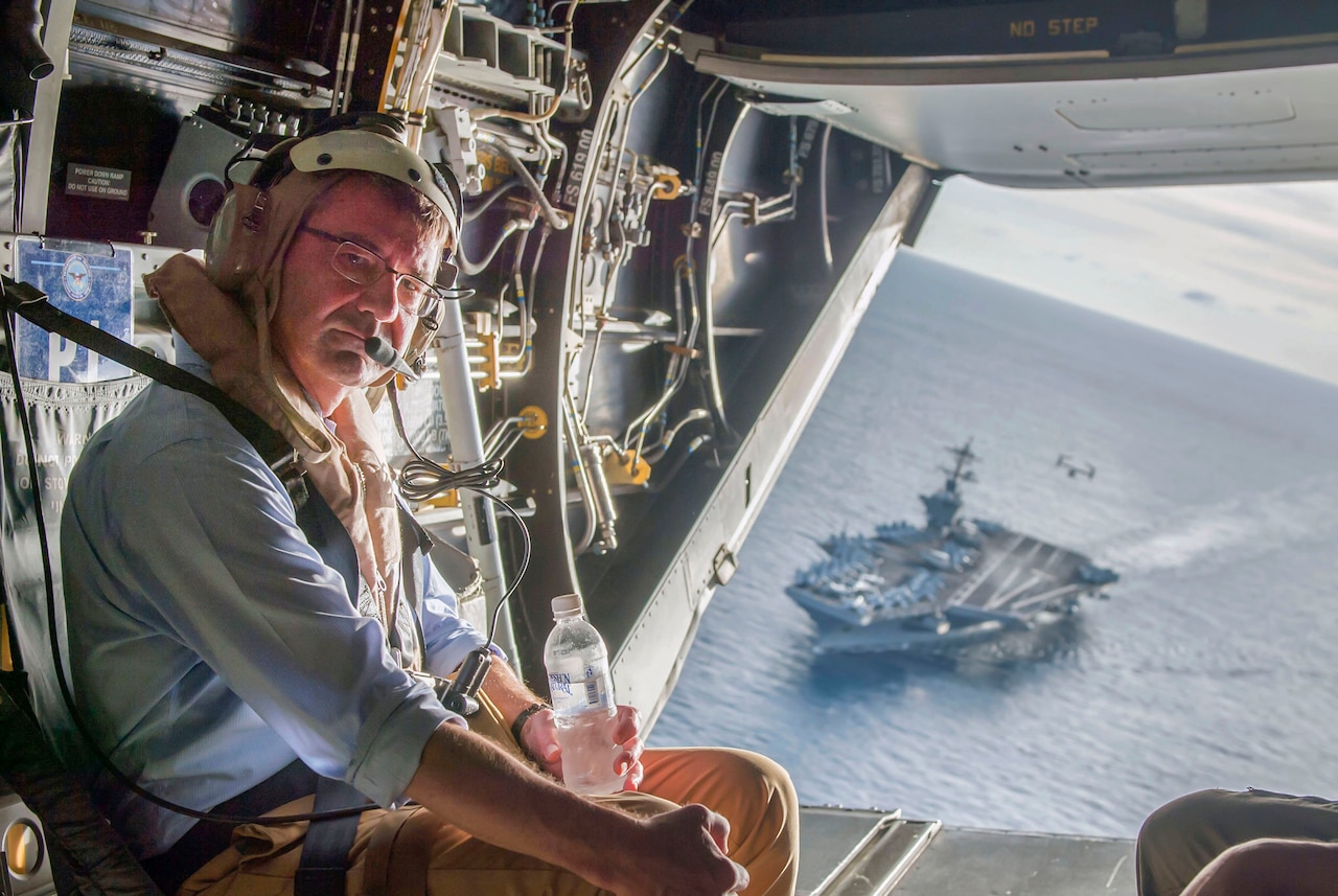 The USS Theodore Roosevelt can be seen in the background as Secretary of Defense Ash Carter flies in a V-22 Osprey after visiting the aircraft carrier with Malaysian Minister of Defense Hishammuddin Hussein Nov. 5, 2015. DoD photo by Air Force Senior Master Sgt. Adrian Cadiz