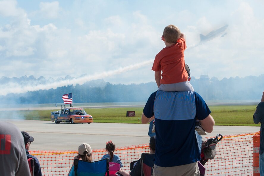 Zach Hagemen and his nephew, Brooks, watch as the Flash Fire Jet Truck speeds down the runway during the Thunder Over South Georgia, Nov. 7, 2015, at Moody Air Force Base, Ga. The jet-powered truck does 0-60 mph in just over one second and has a top speed of 375 miles per hour. (U.S. Air Force photo by Airman 1st Class Kathleen D. Bryant/Released)