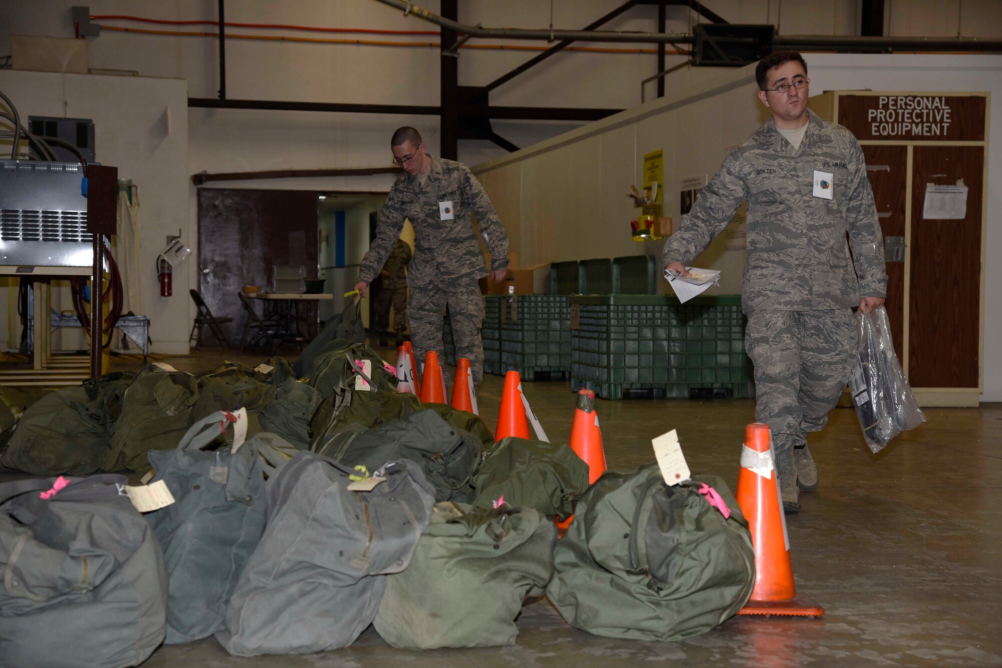 Airmen with the 35th Logistic Readiness Squadron prepare chemical bags during exercise Vigilant Ace 16 at Misawa Air Base, Japan, Nov. 1, 2015. After Airmen out-process through the personnel deployment function line, they travel to the 35 LRS building to receive proper guidance on the use of their mission oriented protective posture gear and the different phases of wearing MOPP gear. (U.S. Air Force photo by Airman 1st Class Jordyn Fetter/Released) 