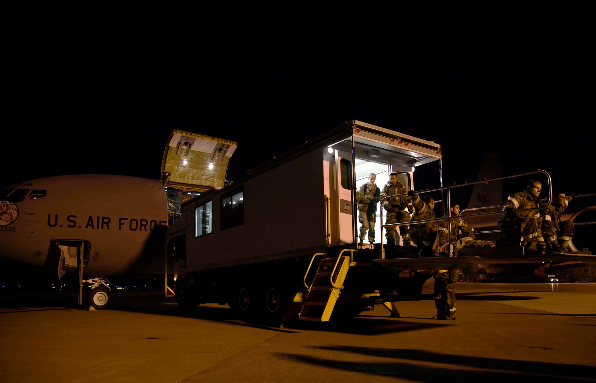 U.S. Air Force Airmen with the 35th Medical Group are lowered from a KC-135 Stratotanker at Misawa Air Base, Japan, Nov. 4, 2015. As part of exercise Vigilant Ace 16, a high deck patient loading platform was connected to the aircraft to remove patients with mock injuries. During the aeromedical evacuation, medical personnel were then testing on their reactions to the wounded and their ability to transport them to the hospital safely. (U.S. Air Force photo by Airman 1st Class Jordyn Fetter/Released)