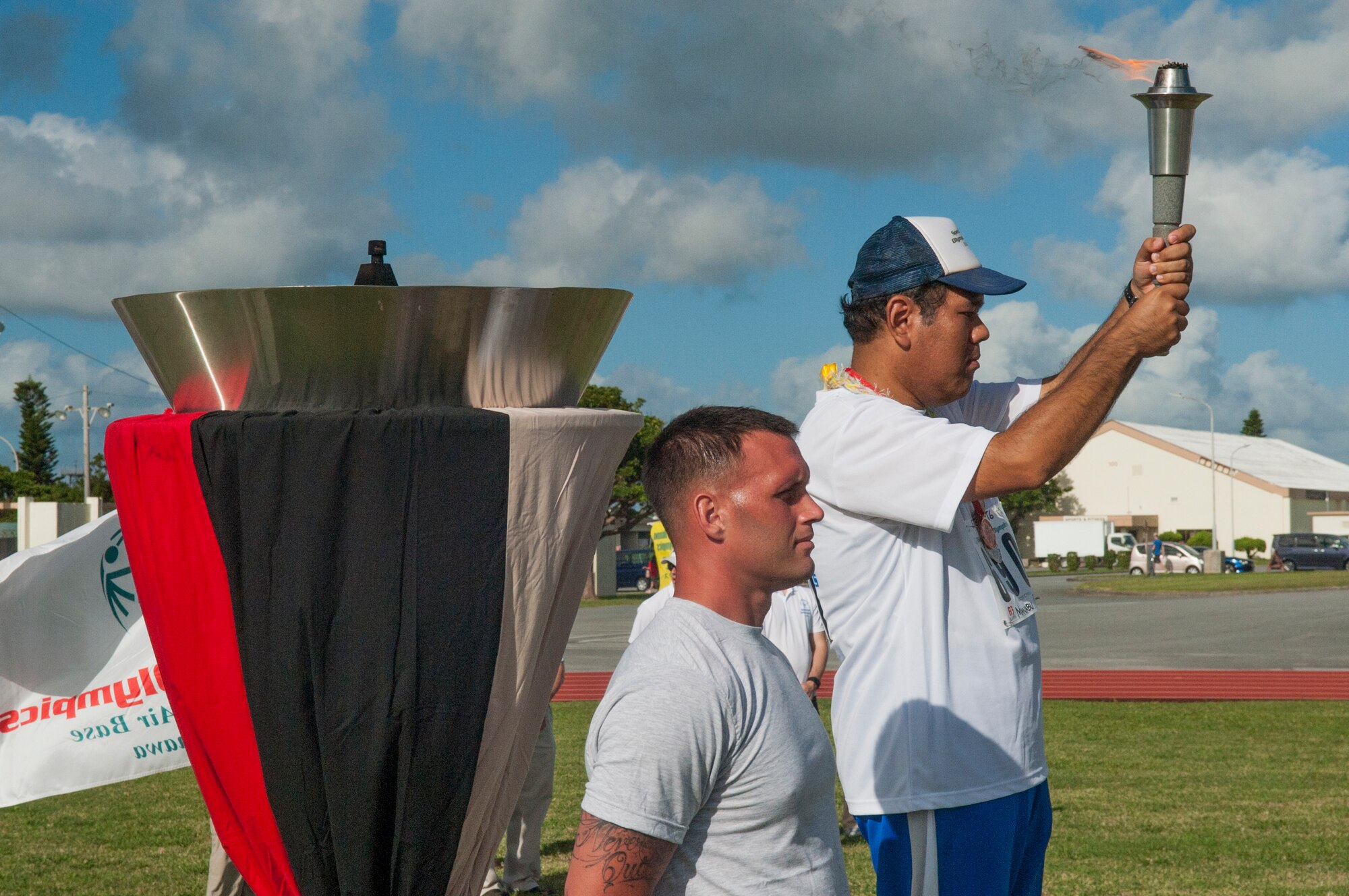 Kadena Special Olympics athlete Manabu Chinen displays the re-lit torch during the closing ceremony of the Kadena Special Olympics Nov. 7, 2015, at Kadena Air Base, Japan. Thousands of spectators from Japan and the U.S. came out to support approximately 880 athletes and artists participating in the 16th annual KSO games and art show. (U.S. Air Force photo by Airman 1st Class Nicholas Emerick)