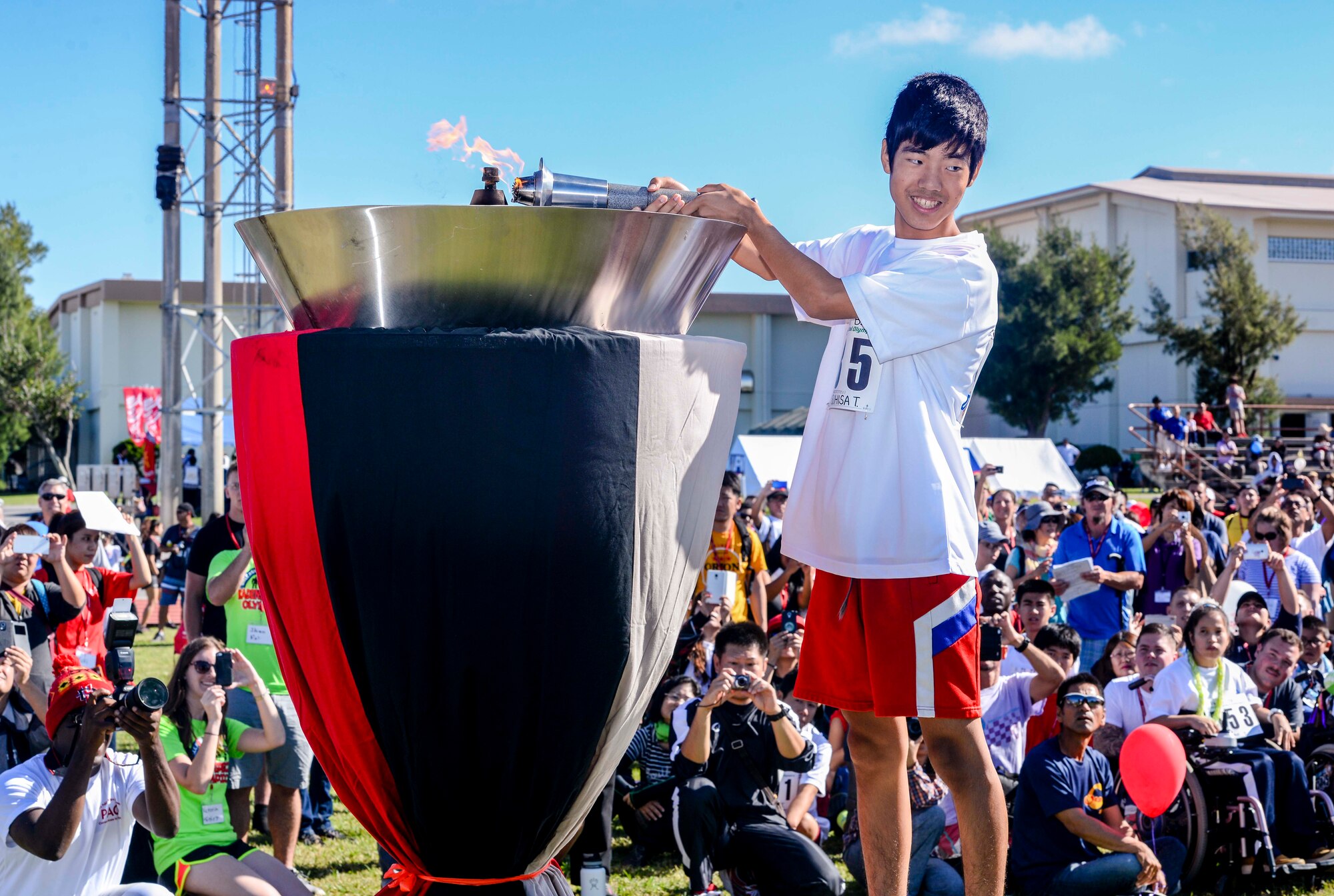 Yasuhisa Tomiyama, a Kadena Special Olympics athlete, lights the torch signaling the start of the games Nov. 7, 2015, at Kadena Air Base, Japan. This year marks the 16th anniversary of KSO, a sporting event dedicated to enriching the lives of American and Okinawan special needs individuals on the island. (U.S. Air Force photo by Senior Airman John Linzmeier) 