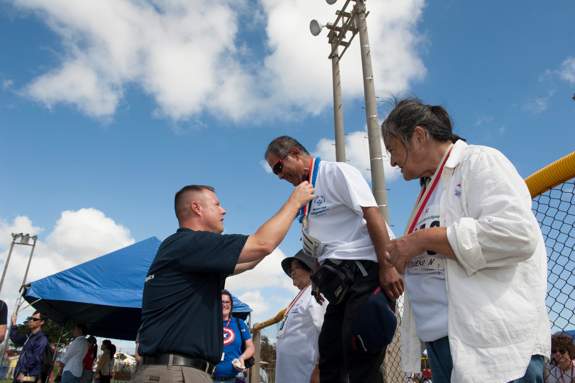 U.S. Air Force Chief Master Sgt. Charles Hoffman, 18th Wing command chief master sergeant, presents a medal to Yukitoshi Iriishigaki, a Kadena Special Olympics athlete, for winning first place in the softball skills tournament during the Kadena Special Olympics Nov. 7, 2015, at Kadena Air Base, Japan. KSO was established by the 18th Wing commander in 2000 as an avenue to build relations with the local communities and government representatives while providing a meaningful activity for members of the special needs community on Okinawa. (U.S. Air Force photo by Airman 1st Class Lynette M. Rolen)
