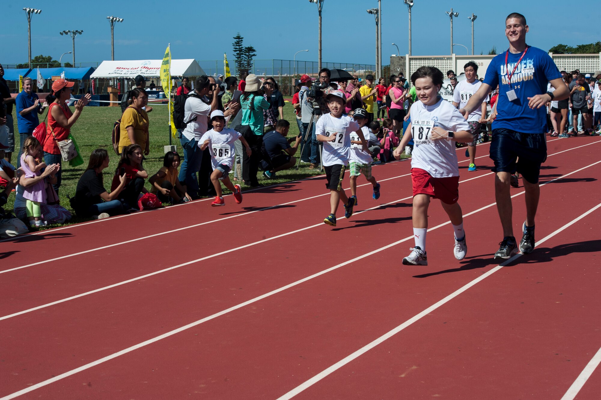 U.S. Air Force Airman 1st Class Anthony Sojka, 18th Component Maintenance Squadron aerospace propulsion apprentice, runs with Teisan Scarborough, a Kadena Special Olympics athlete, during the Kadena Special Olympics Nov. 7, 2015, at Kadena Air Base, Japan. Approximately 1700 volunteers helped nearly 900 athletes arrive to their events and compete in the largest overseas Special Olympics in the world. (U.S. Air Force photo by Airman 1st Class Lynette M. Rolen)