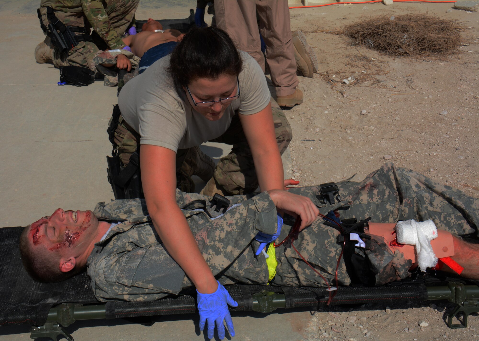 Capt. Susan Daoust, 379th Expeditionary Medical Group orthopedic surgeon, secures a patient to a litter during a mass-casualty exercise at Al Udeid Air Base, Qatar Nov. 6. The exercise provided medical teams with an opportunity to provide care for patients in a mass-casualty situation. Teams were evaluated on set up, patient movement and communication. (U.S. Air Force photo by Tech. Sgt. James Hodgman)