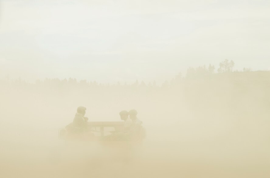 The 919th Special Operations Security Forces Squadron Airmen are barely visible while riding in a Humvee through the dusty landscape of Camp Guernsey, Wyo., Aug. 4. More than 20 Airmen went out West to help train two other Reserve security forces squadrons in ground combat and field training as part of their annual training. The 919th SOSFS Airmen lived in the makeshift camps and acted as opposing forces and local villagers interacting with the occupying security teams.  (U.S. Air Force photo/Tech. Sgt. Sam King) 