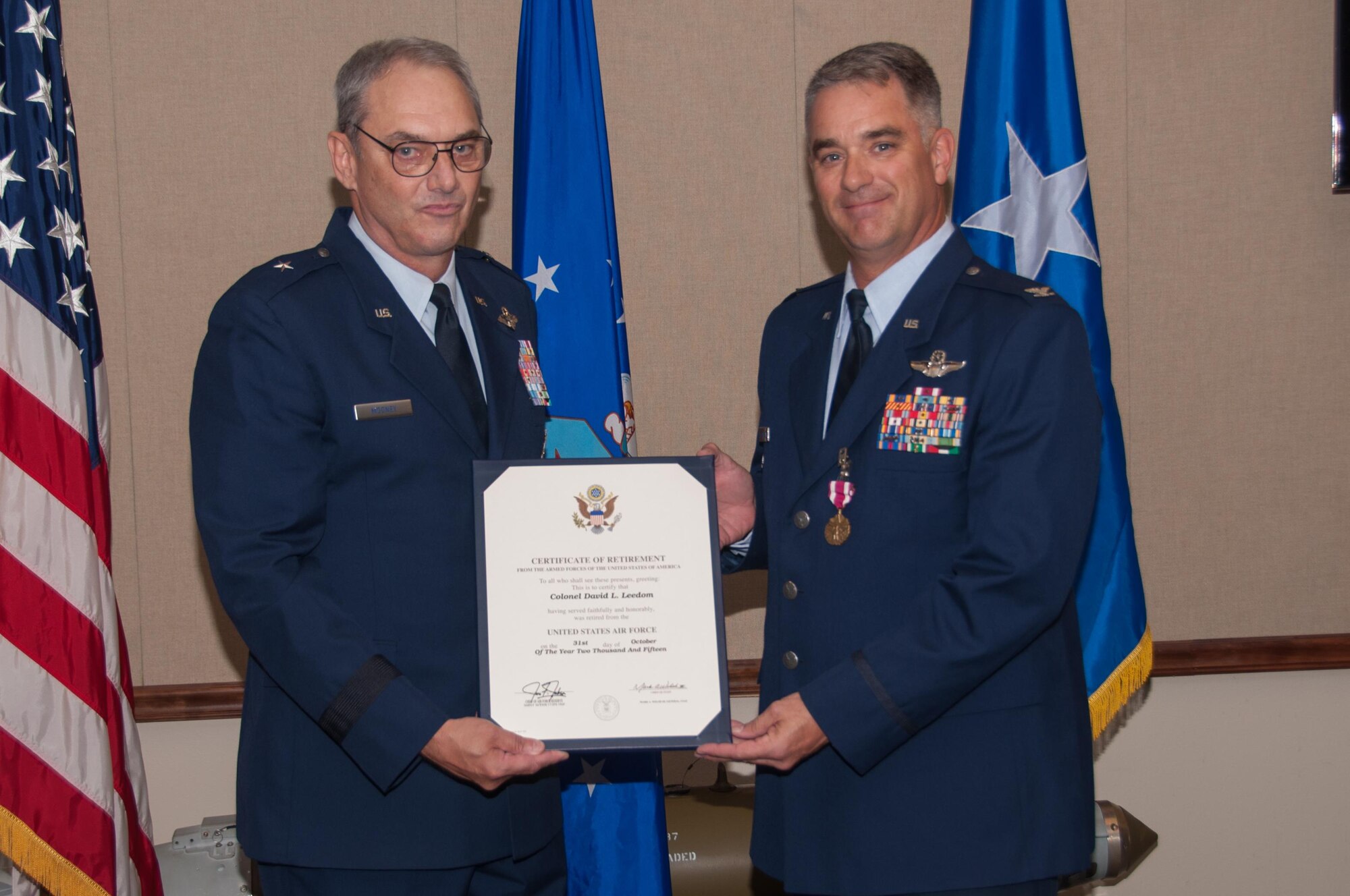 U.S. Air Force Brig. Gen. John Mooney, Air Force Reserve Inspection General, presents Col. David Leedom, former Reserve Advisor to the 8th Air Force Commander, with a certificate of retirement on October 30, 2015 at Barksdale Air Force Base, La. Leedom has also served an Evaluator Pilot and the commander of the 93rd Bomb Squadron and is retiring with over 27 years of service. (U.S. Air Force photo by Master Sgt. Laura Siebert/Released)