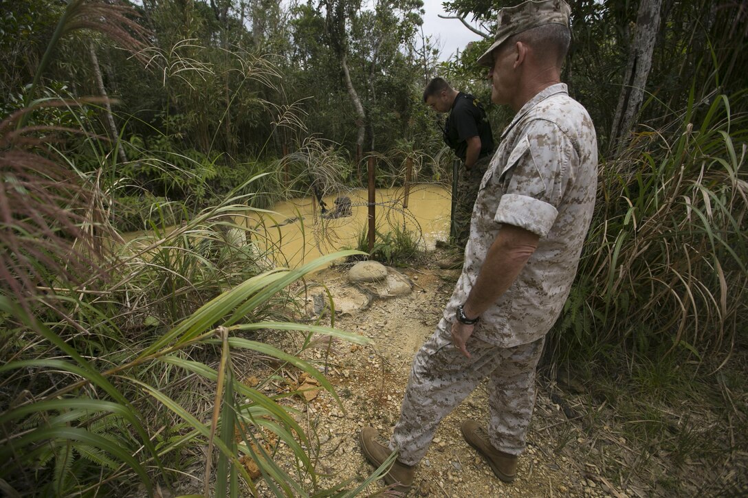 Maj. Gen. James W. Lukeman observes Marines completing the “Pit and Pond” portion of the endurance course Oct. 30, aboard Camp Gonsalves, Okinawa, Japan. Lukeman received a tour of the facility’s obstacle courses and ranges. Lukeman, a Beaufort, South Carolina, native, is the commanding general with Training and Education Command.