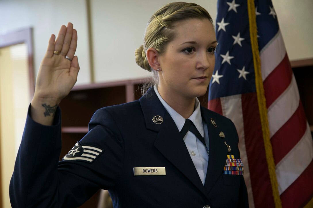 Tech. Sgt. Brittany E. C. Bowers recites the oath of enlistment during the ceremony of her promotion to tech sergeant Oct. 30 at the Marine Corps Installations Pacific Headquarters on Camp Foster, Okinawa, Japan. Bowers serves in the Nebraska Air National Guard, as an aircrew flight equipment craftsman, and currently works as a paralegal for the Pacific Area Counsel Office, Marine Corps Installations Pacific-Marine Corps Base Camp Butler, Japan. “My military commitment consists of 12 weekend drills throughout the year and 15 annual training days, totaling to 39 duty days and approximately 8 weeks,” said Bowers, a Columbus, Ga., native. Bowers’ unit, the 170th Operations Group at Offutt Air Force Base, Neb., places her on orders once per year to travel back to the U.S. to fulfill her military commitment. (U.S. Marine Corps Photo by Cpl. Brittany James/Released)