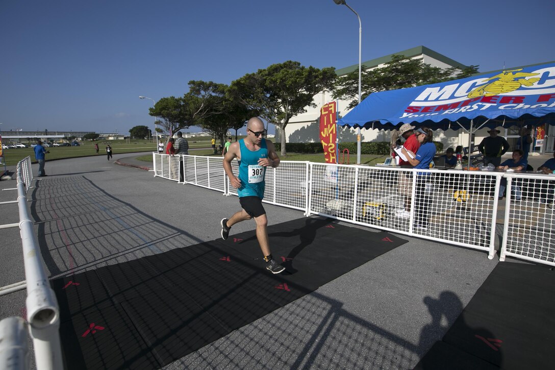 Lance Cpl. Anthony Stevens crosses the finish line during the Habu Fun Run Oct. 26 on Marine Corps Air Station Futenma, Okinawa, Japan. Runners chose one of two paths at the beginning of their cardiovascular journey, either a five kilometer or 10 kilometer course. Stevens is a personnel clerk with Installation Personnel Administration Center, Headquarters and Support Battalion, Marine Corps Installations Pacific-Marine Corps Base Camp Butler, Japan.
