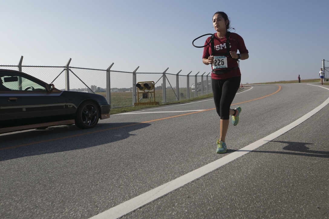 Ana Gonzalez runs intently during the Habu Fun Run Oct. 26 on Marine Corps Air Station Futenma, Okinawa, Japan. Runners chose one of two paths at the beginning of their cardiovascular journey, either a five kilometer or 10 kilometer course.