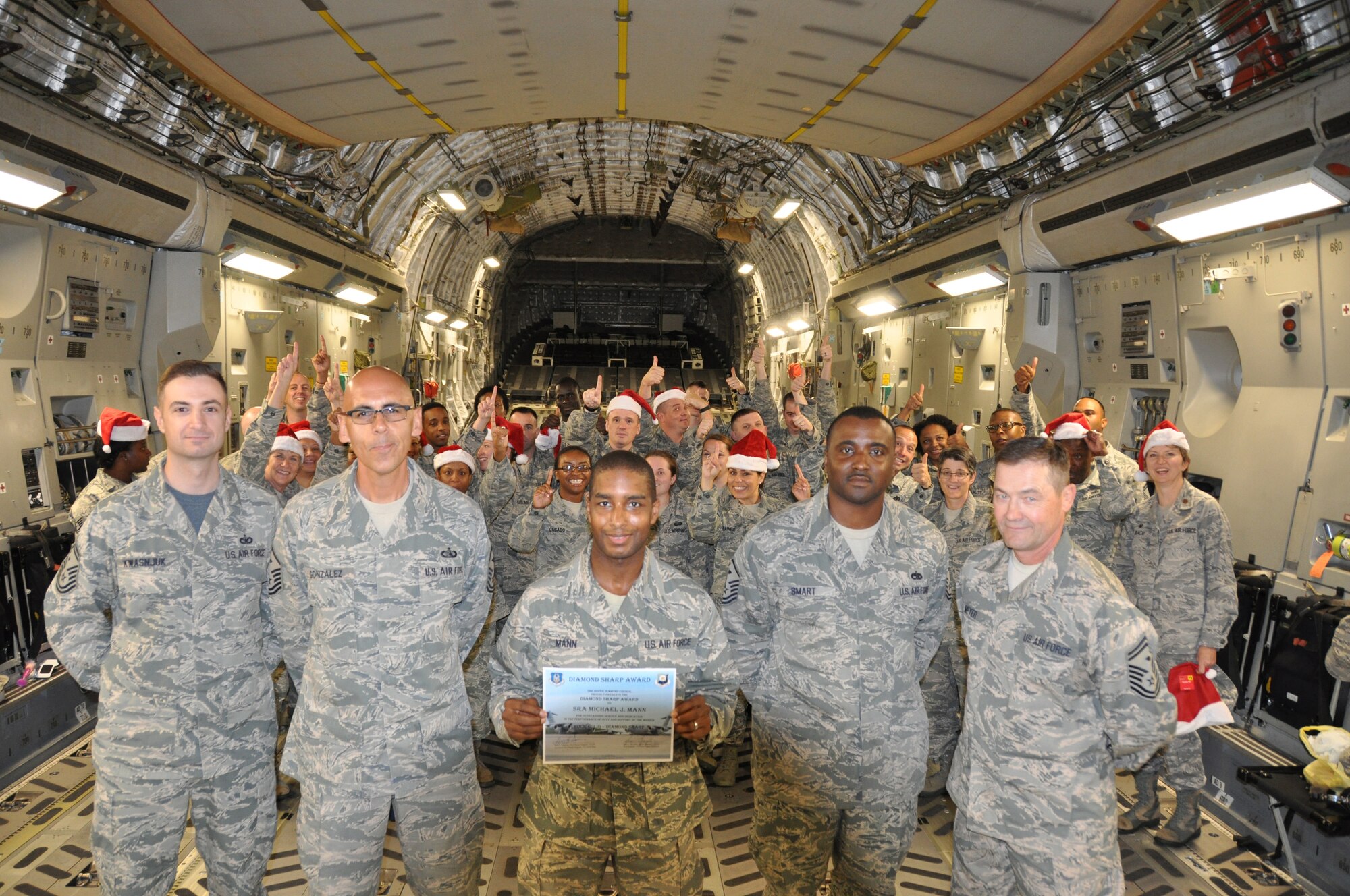 SrA Michael Mann, 512th Force Support Squadron, displays his certificate for the Diamond Sharp Award in front of his squadron wingmen Nov. 7, 2015, at Dover Air Force Base, Del. The award, presented to Mann by the Dover Diamond Council, is in recognition of his outstanding service and dedication to duty. (U.S. Air Force/Staff Sgt. Joe Yanik)