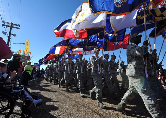 A crowd cheers on Barksdale Airmen as they march in formation carrying U.S. state flags during the Veterans Parade at the State Fair of Louisiana in Shreveport, La., Nov. 8, 2015. Every state flag was represented in the procession, joined by the American flag, Prisoner of War flag, Military Order of the Purple Heart flag and others. (U.S. Air Force photo/ Senior Airman Joseph Raatz)
